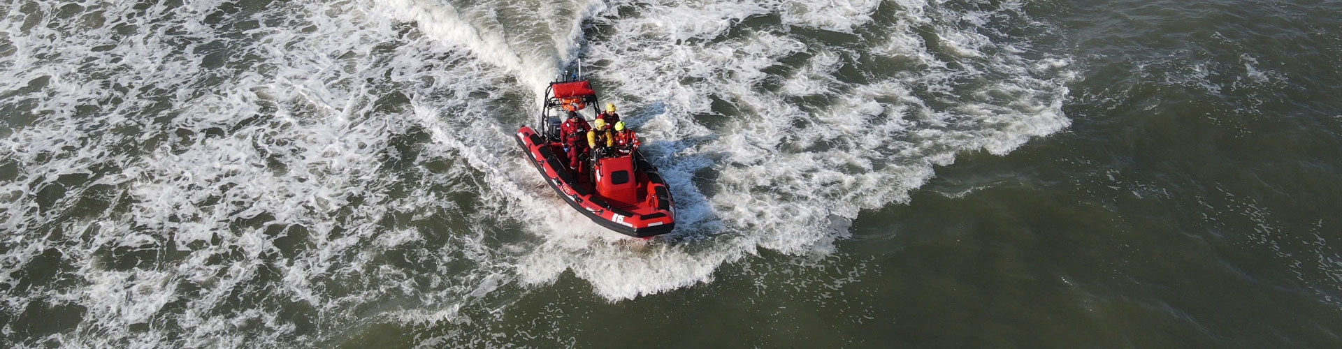 Obraz przedstawiający płynącą łódź ratowniczą z załogą